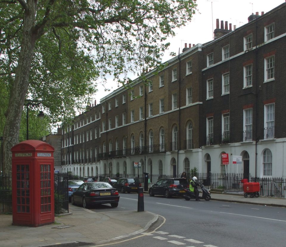 A red telephone box beside a Georgian terrace on Regent Square in Holborn, London